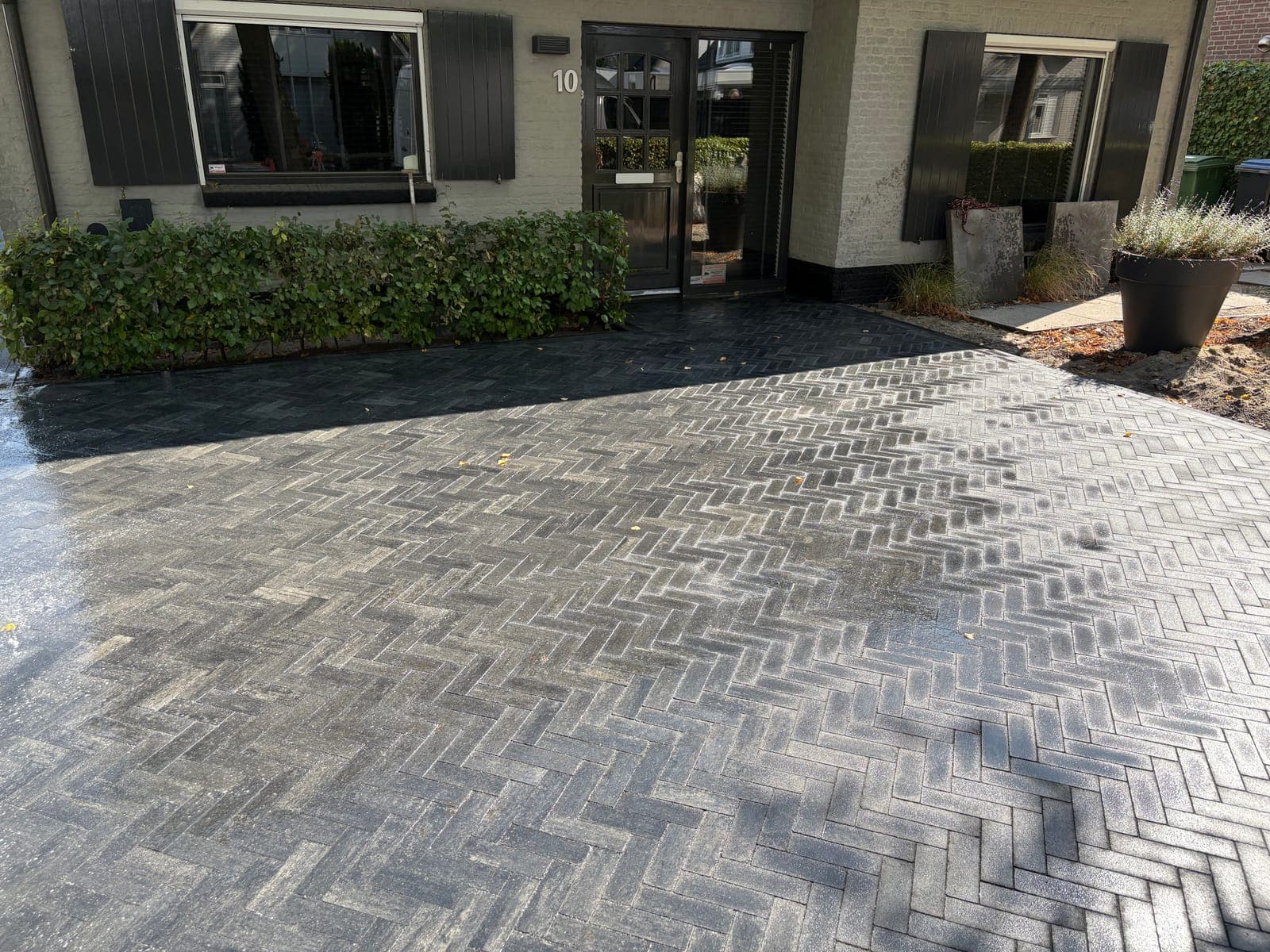 Oprit in donkere klinkers in keperverband bij een woning